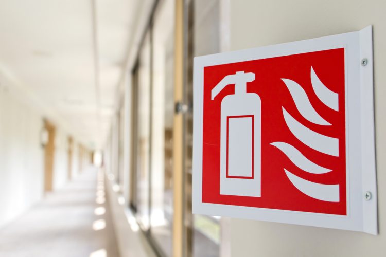 Close,Up,Fire,Extinguisher,Sign,In,The,Building,Corridor.,Selective
